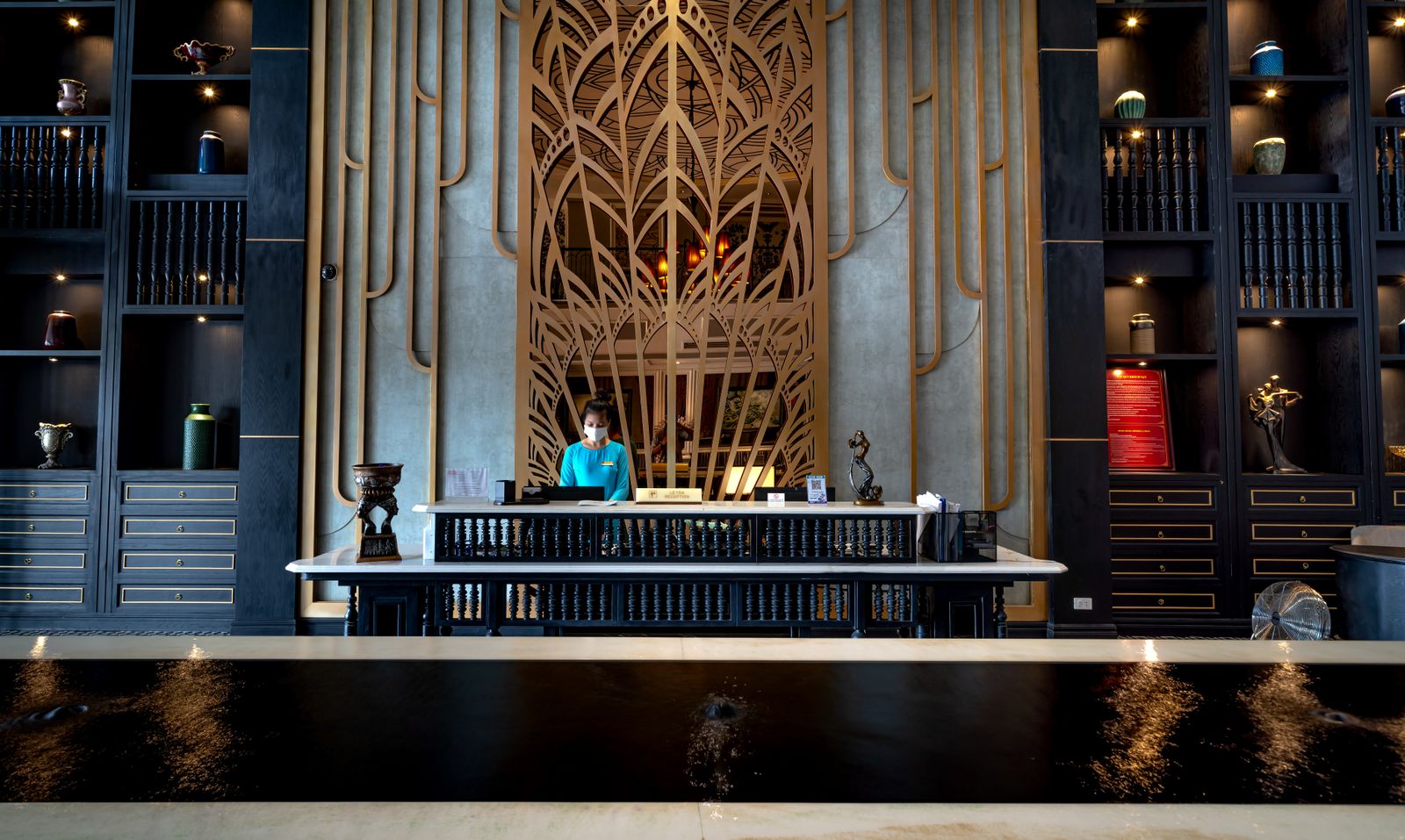 A receptionist at the front desk of a hotel lobby A receptionist at the front desk of a hotel lobby