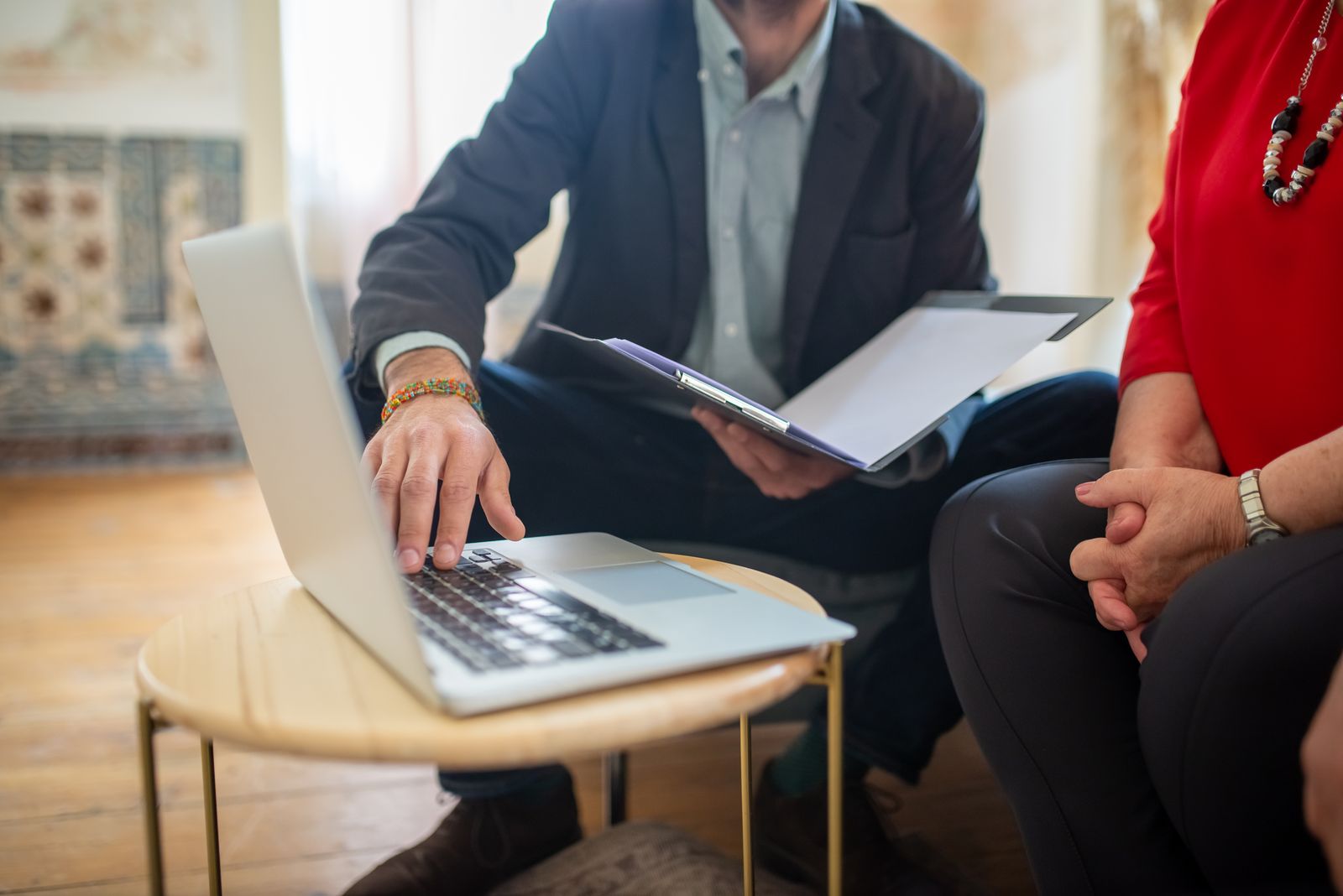 A lawyer going through documents with a client at a laptop A lawyer going through documents with a client at a laptop