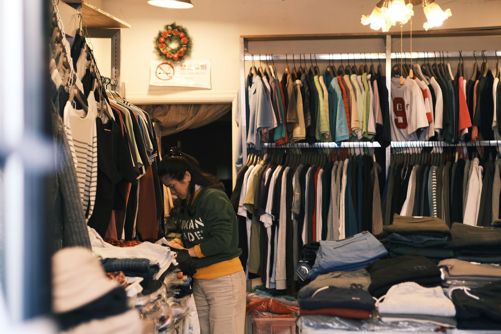 A shop owner sorting stock in a small clothing boutique A shop owner sorting stock in a small clothing boutique